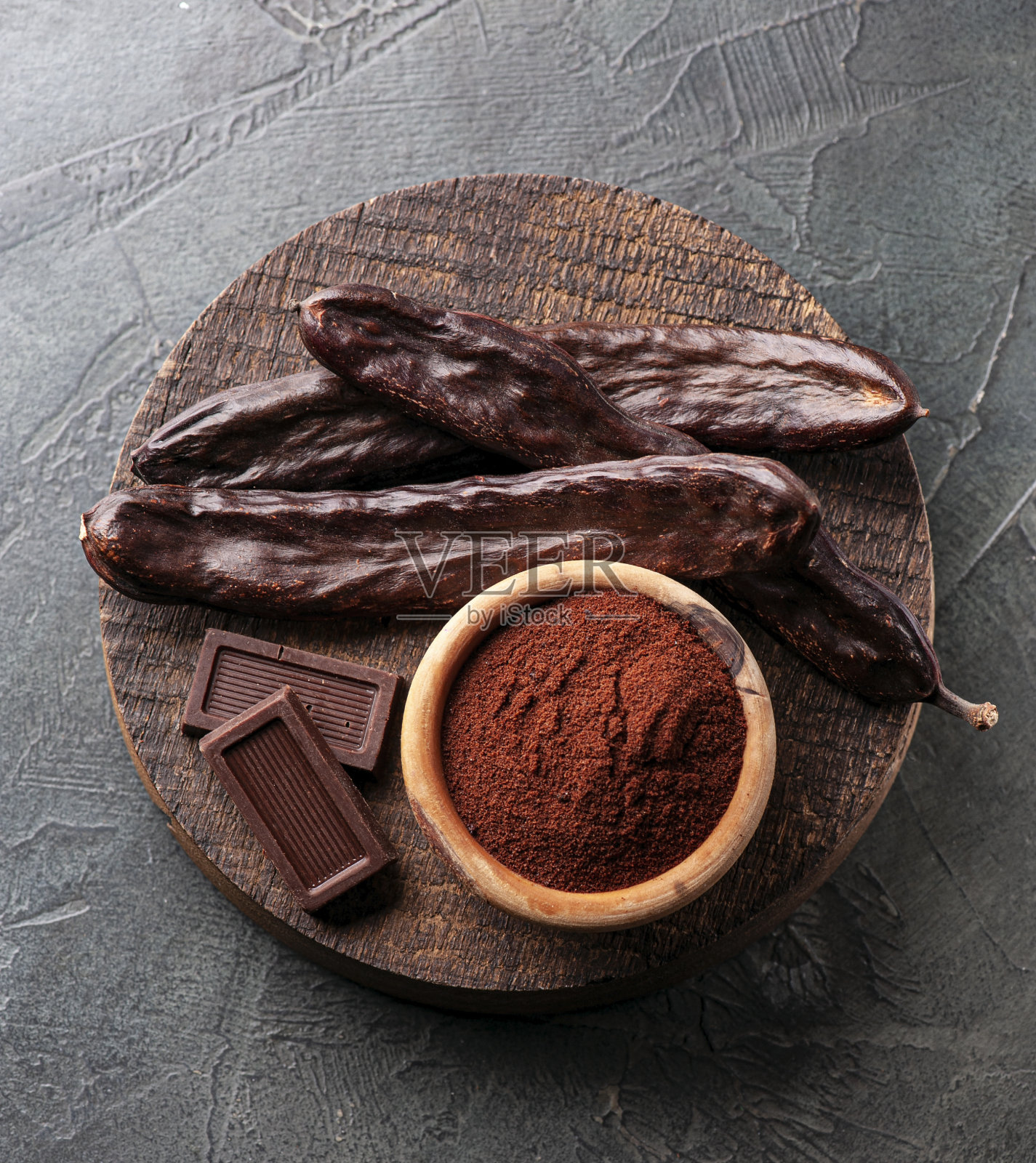 角豆荚和角豆粉在木板上特写。照片摄影图片