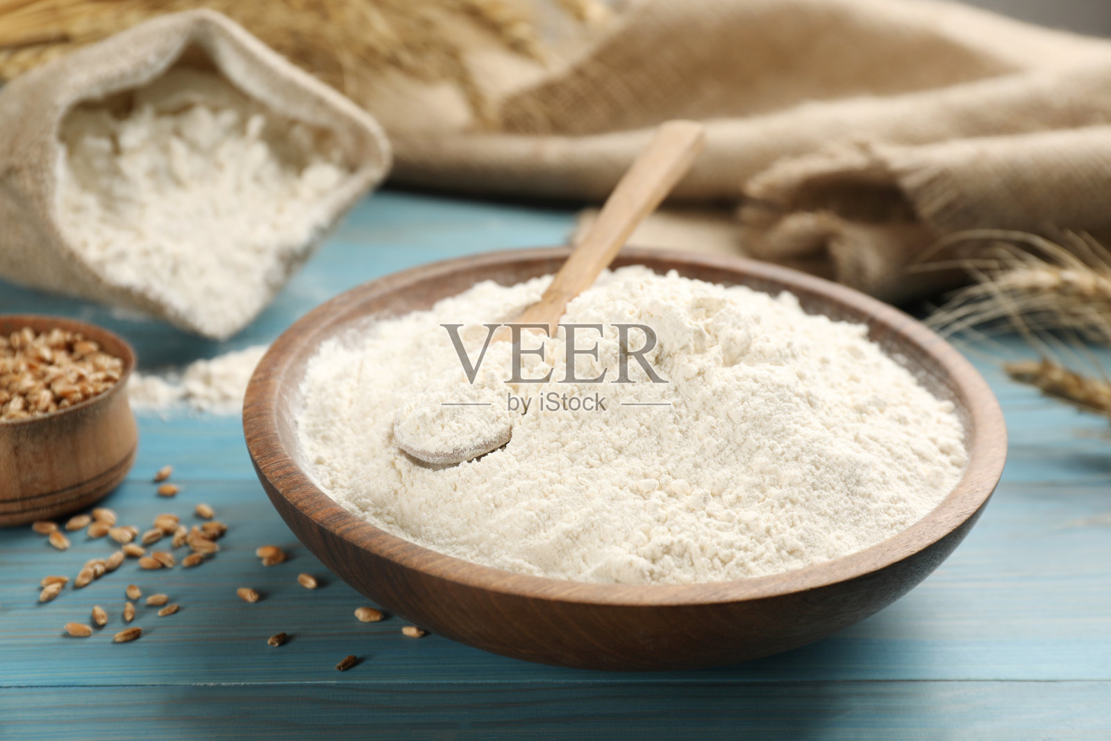 面粉放在碗里，浅蓝色的木桌上照片摄影图片