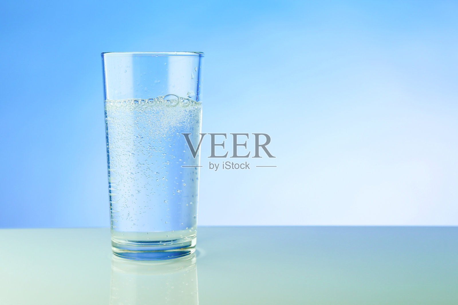 蓝色背景下一杯波光粼粼的水照片摄影图片