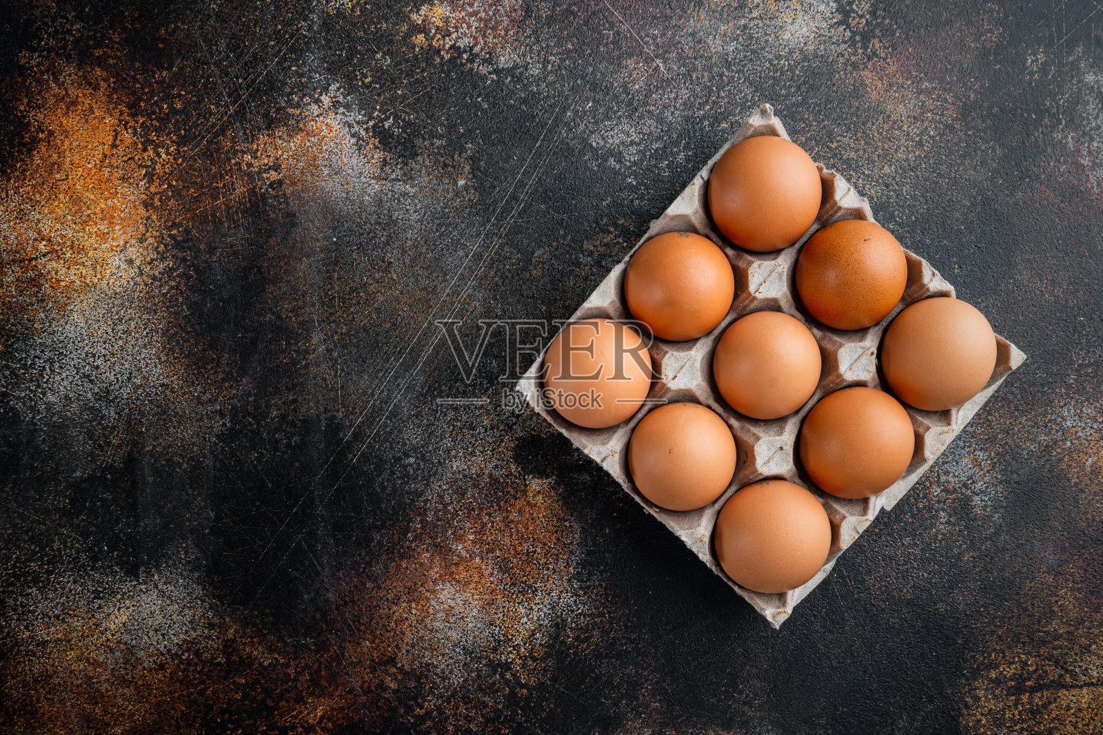 鸡蛋放在鸡蛋盒的托盘上，放在老旧的深色乡村背景上，俯视图平放，留有文字拷贝空间照片摄影图片