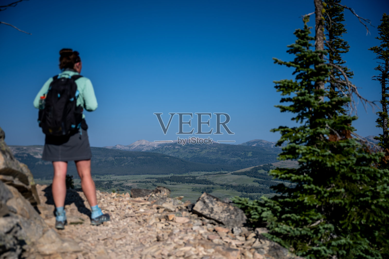 看着黄石山谷过去的褐发徒步者照片摄影图片