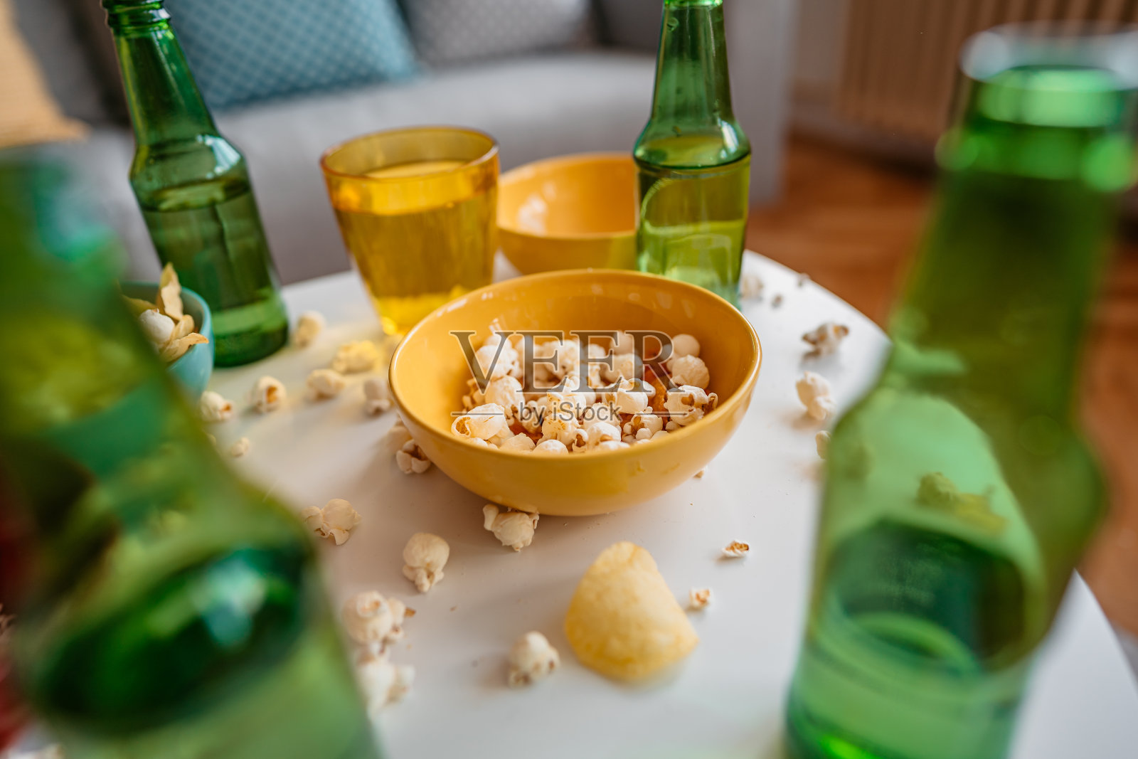 游戏之夜后桌上有爆米花和啤酒瓶照片摄影图片