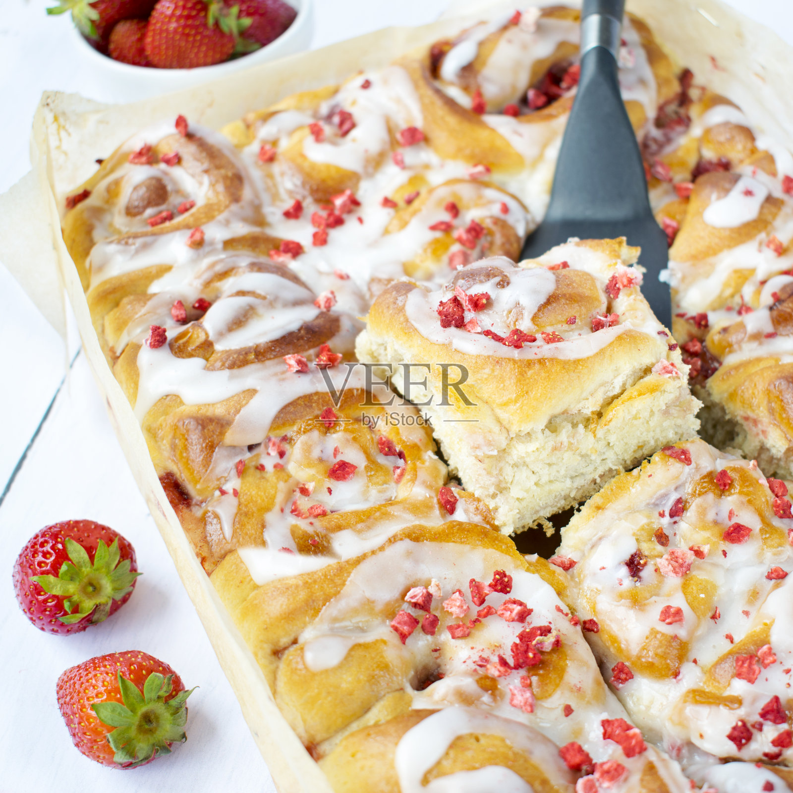 香草酵母卷，草莓和糖霜。照片摄影图片