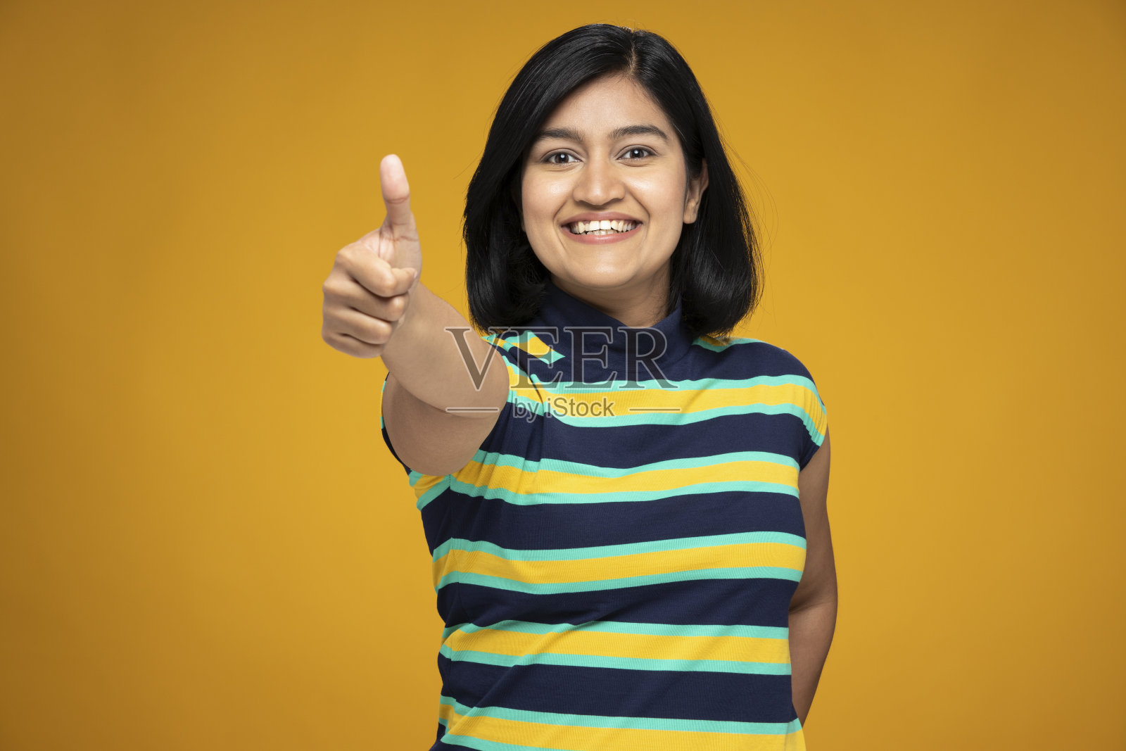 年轻妇女的肖像在短头发站孤立的黄色背景:股票照片照片摄影图片