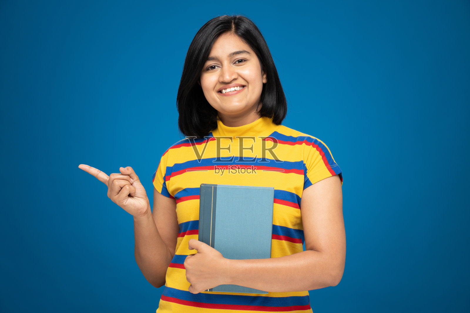 年轻女性的肖像在短头发站孤立的蓝色背景:库存照片照片摄影图片