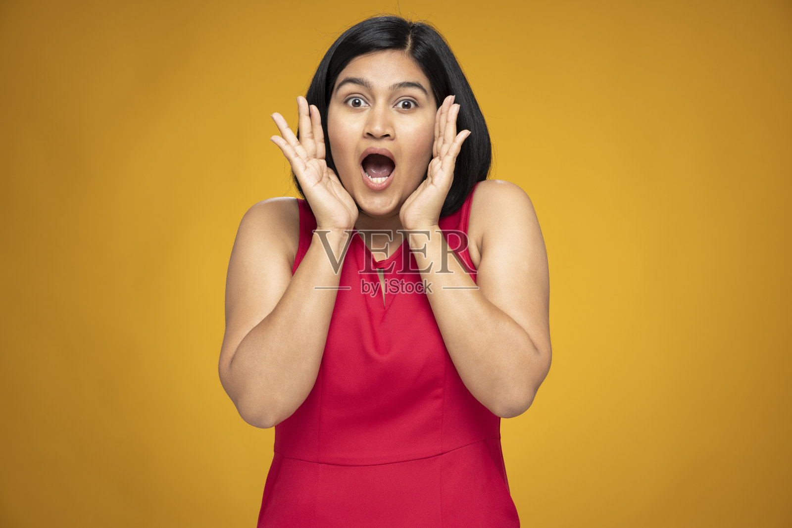 年轻妇女的肖像在短头发站孤立的黄色背景:股票照片照片摄影图片