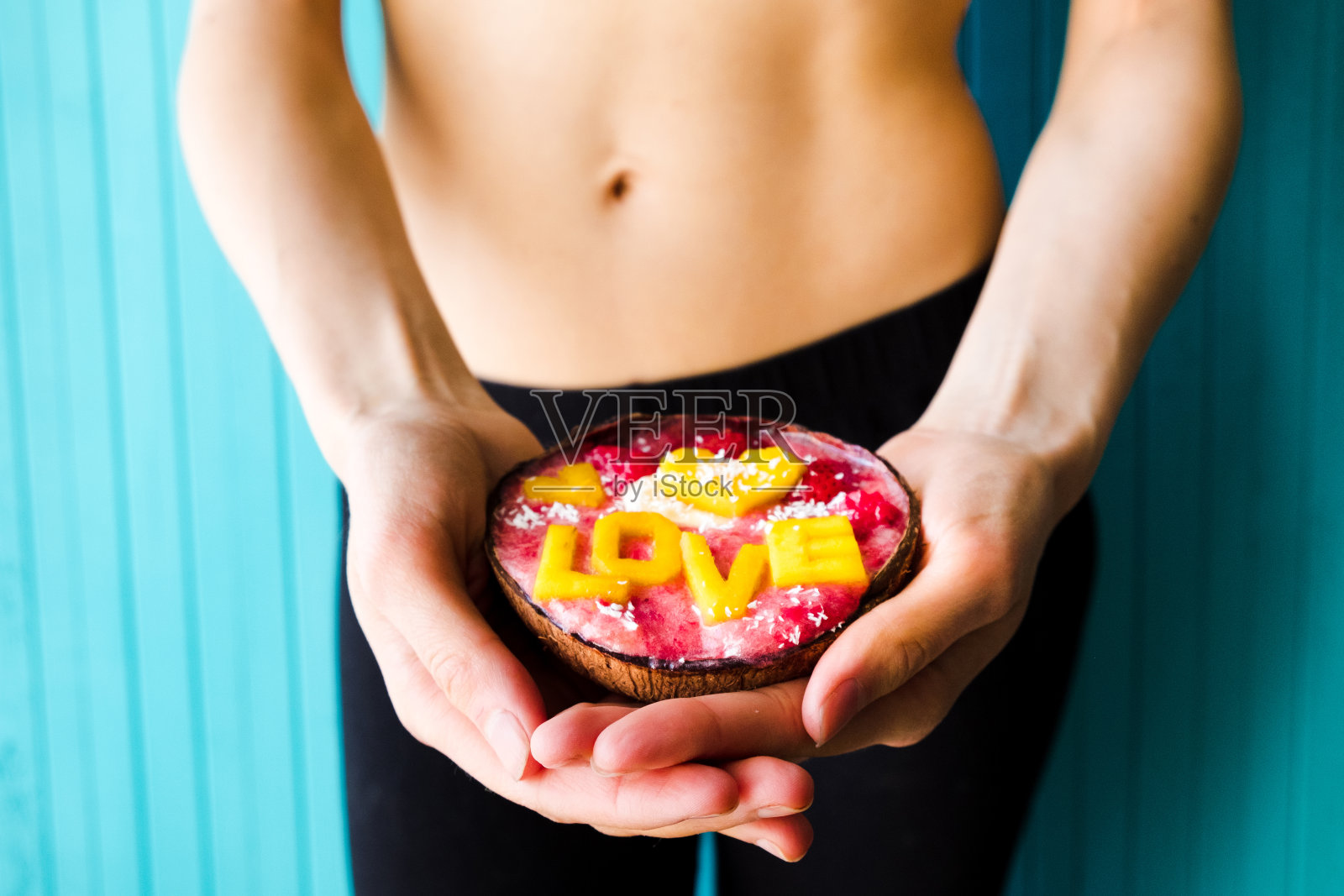 饮食的概念，适当的营养和健康。苗条的女人拿着冰沙碗在绿松石的背景照片摄影图片