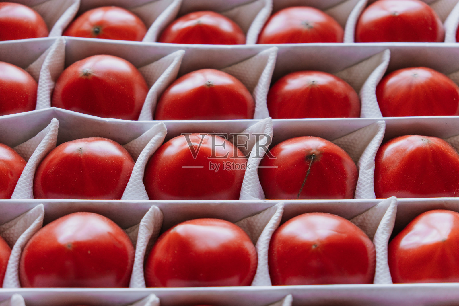 熟透的西红柿放在一个盒子里，水果分开放照片摄影图片