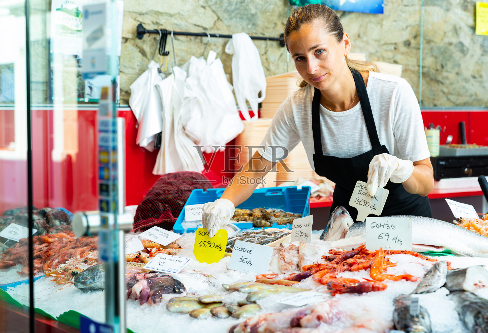 在海鲜陈列室工作的售货员照片摄影图片