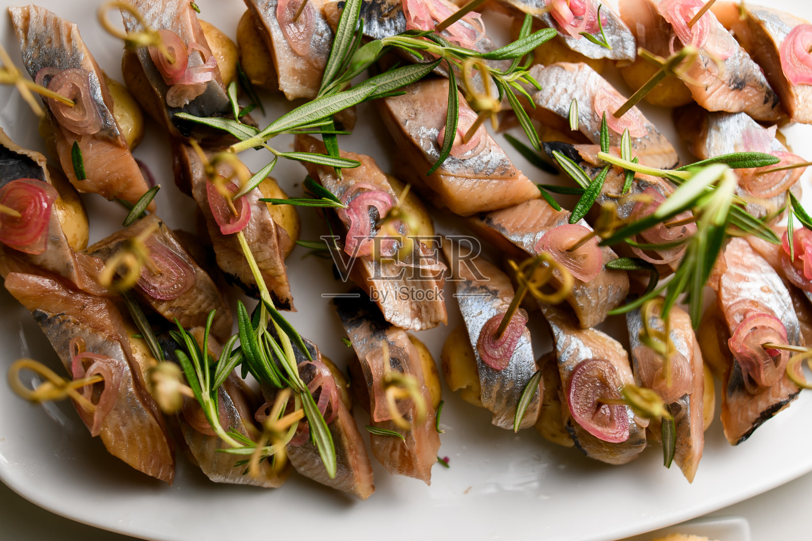 以迷迭香装饰的醋腌鲱鱼片照片摄影图片