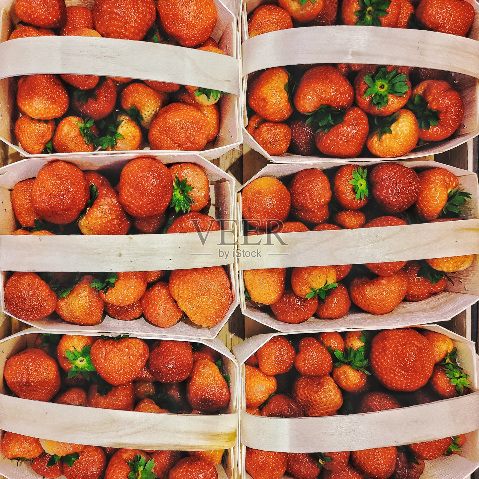 市场上的草莓装在木篮子里照片摄影图片