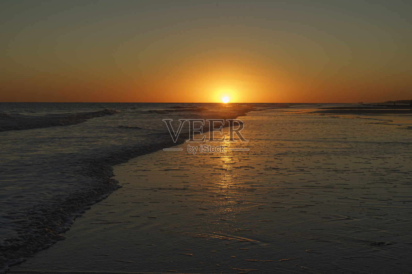 海滩上的日落。海浪和海岸的倒影照片摄影图片