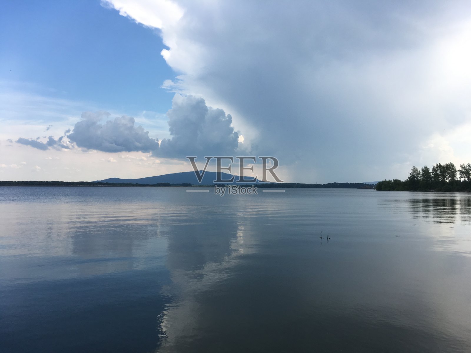 水面上乌云密布。背景是山。波兰的米特科夫泻湖照片摄影图片