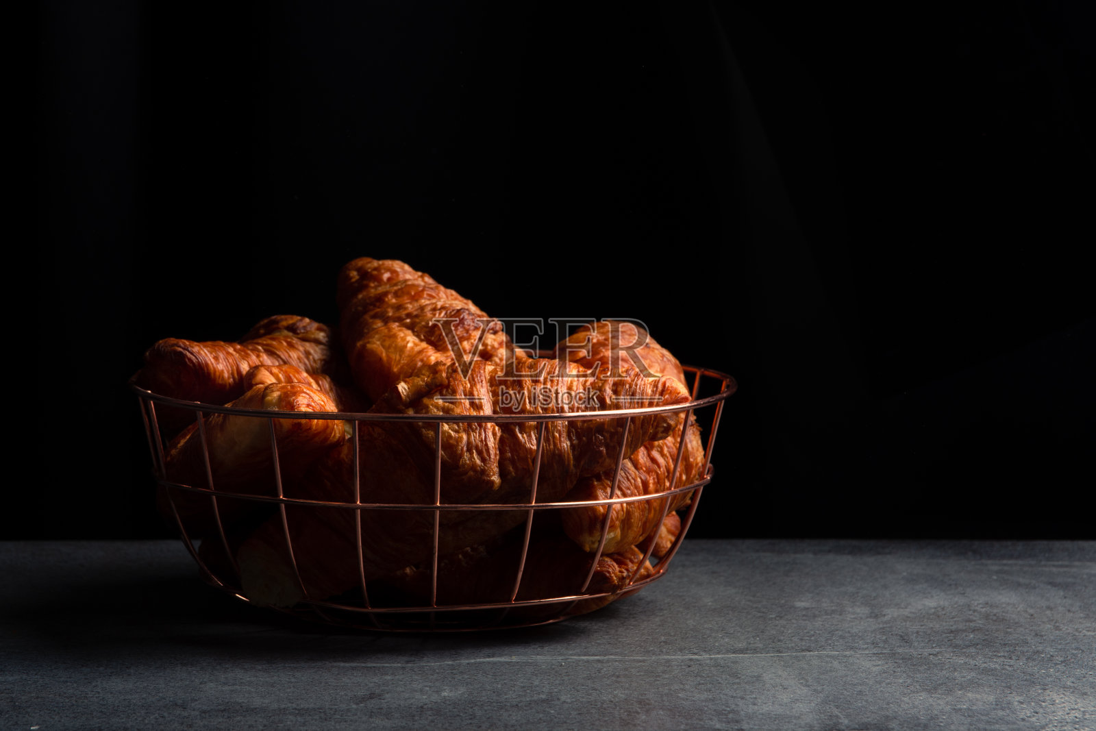 深色背景上是新鲜出炉的黄油牛角面包。照片摄影图片