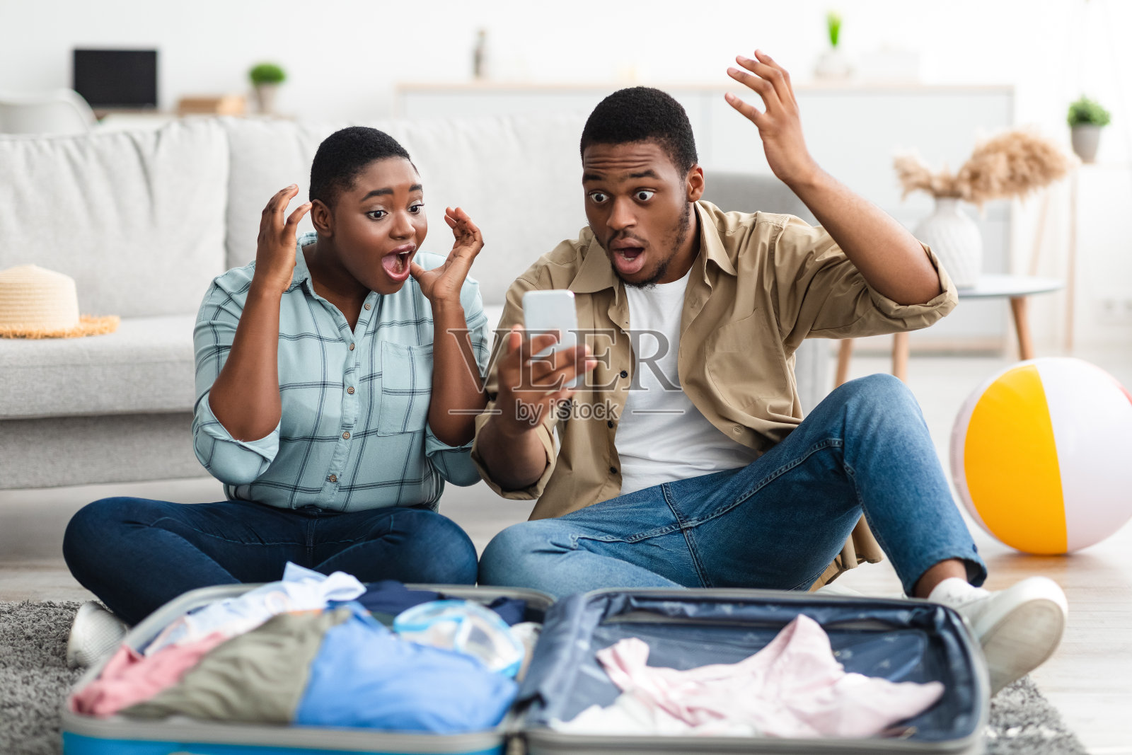 震惊的非洲夫妇用智能手机在家阅读旅游新闻照片摄影图片