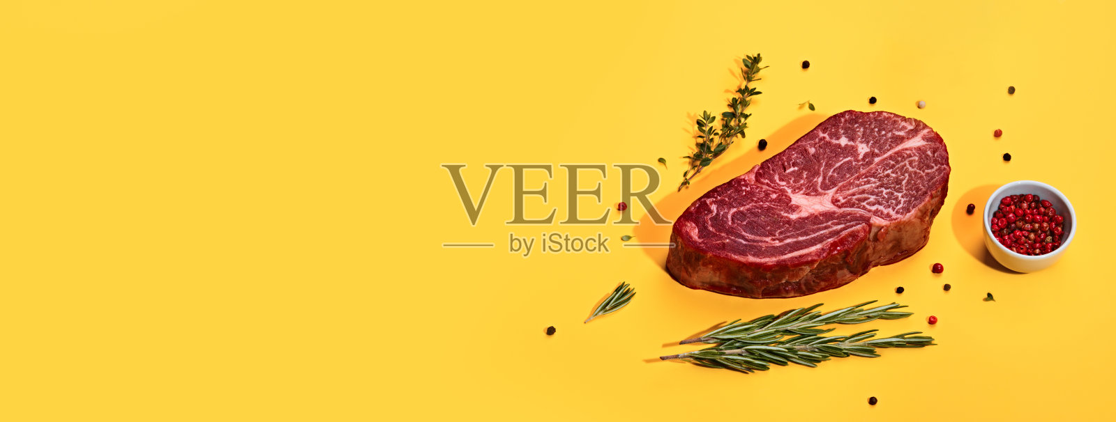 新鲜的大理石牛排和香料在黄色旗帜，时尚的阴影照片摄影图片