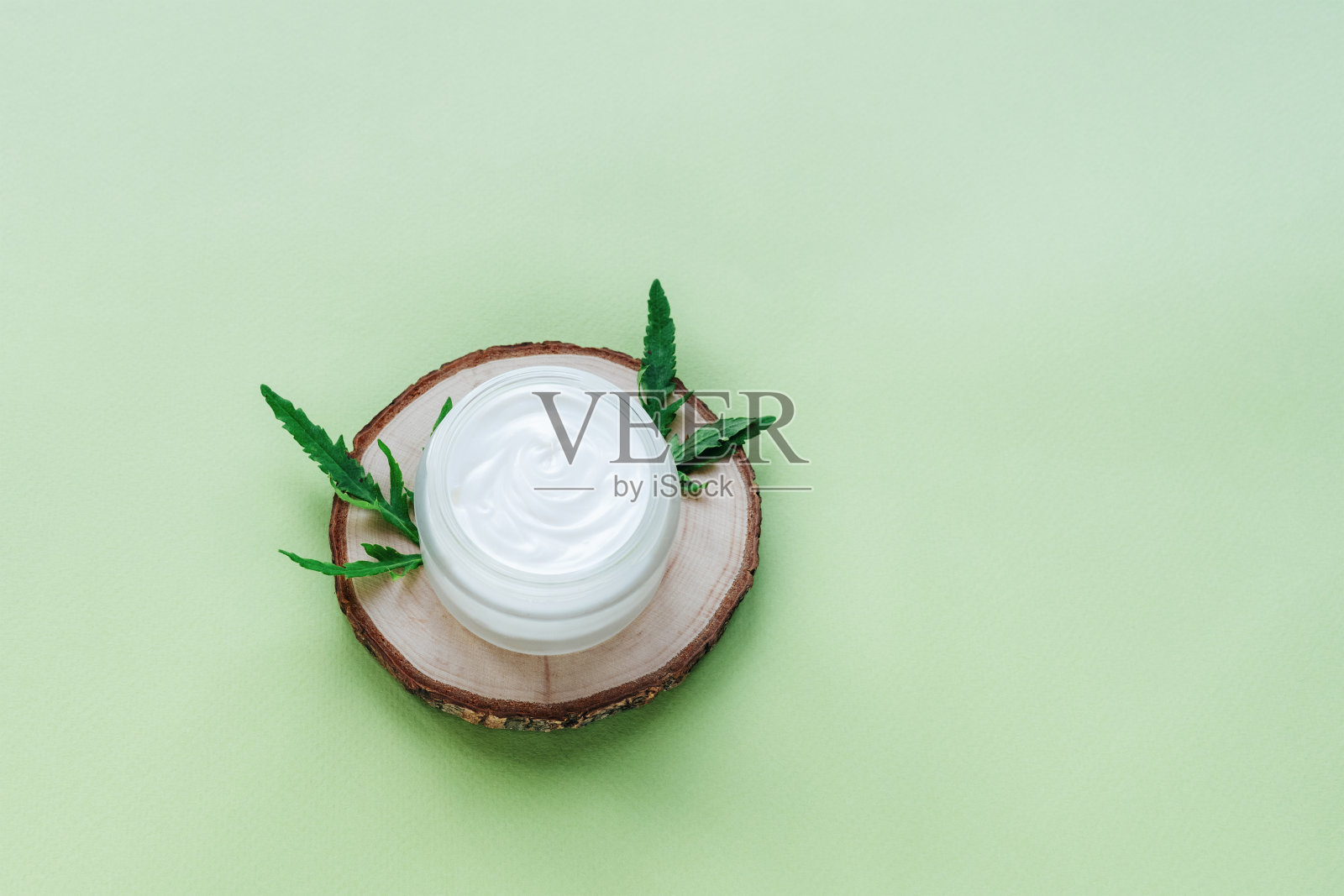 木架上的奶油罐，绿色背景。天然有机护肤化妆品概念。俯视图，复制空间照片摄影图片