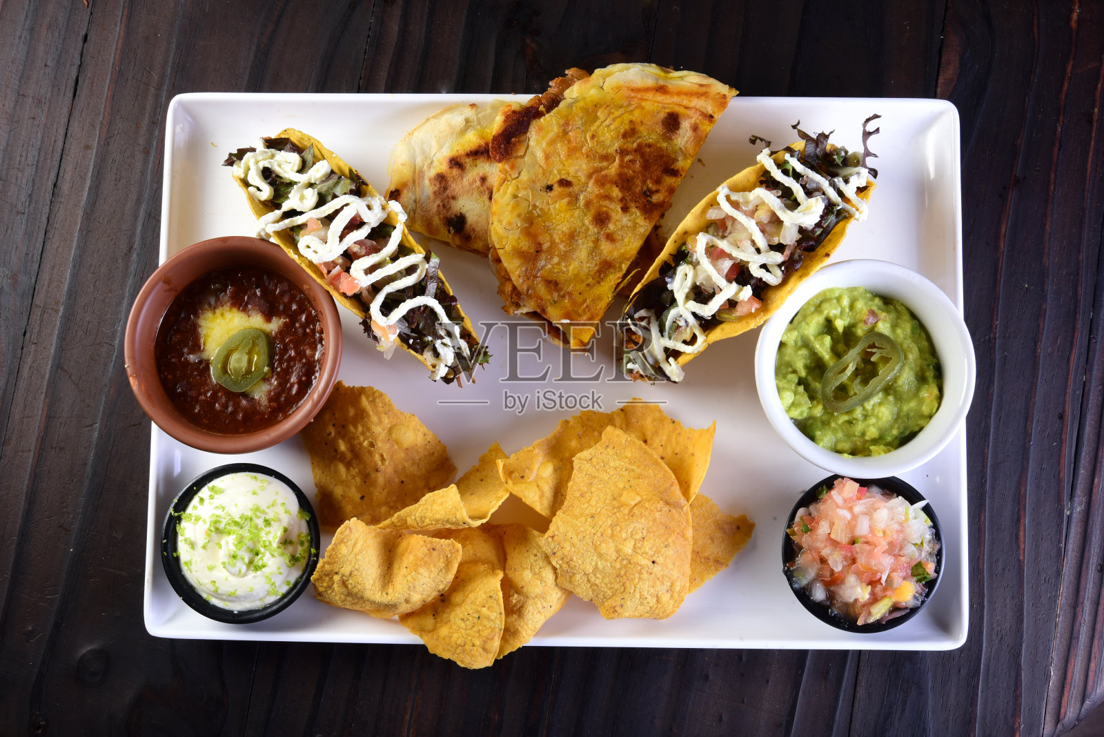 美味的墨西哥料理鳄梨色拉酱，墨西哥玉米卷，玉米粉圆饼，辛辣的墨西哥辣椒照片摄影图片