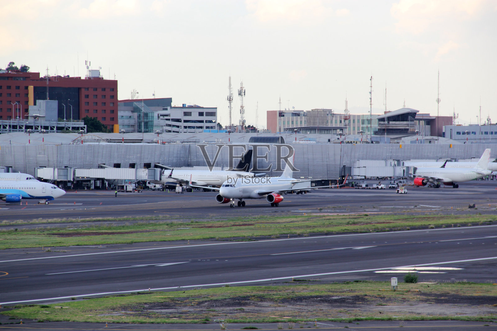 商业飞机在蓝天白云下停靠、起飞或降落在跑道上照片摄影图片