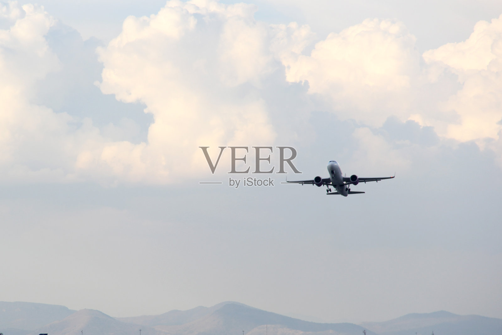 飞机在蓝天白云和高山之间的跑道上起飞或降落照片摄影图片