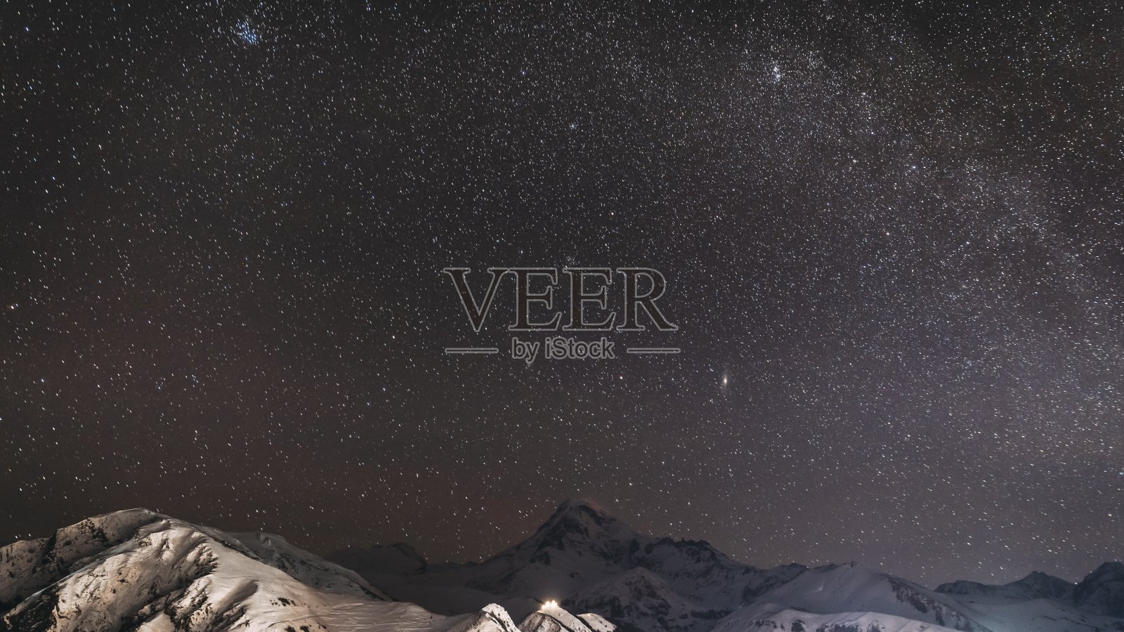 Stepantsminda,格鲁吉亚。哈萨克雪峰上的冬夜繁星满天。美丽的夜晚格鲁吉亚冬季景观照片摄影图片