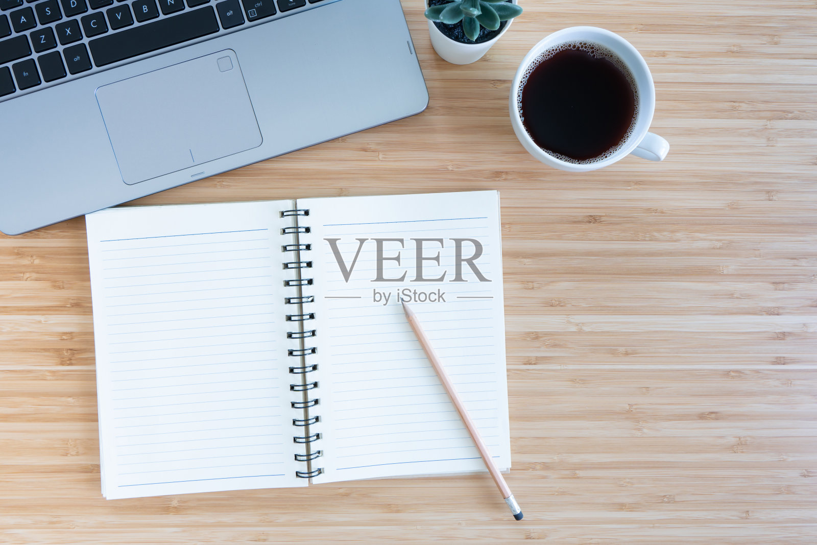 平铺构图以笔记本、笔、咖啡、植物、笔记本木为背景。俯视图照片摄影图片