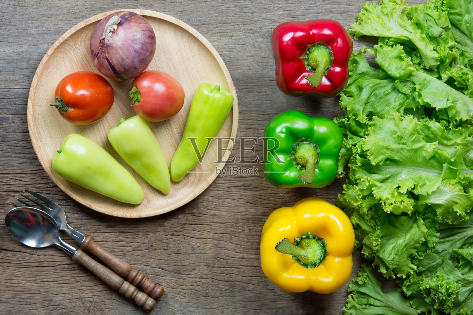 新鲜蔬菜沙拉和绿色蔬菜放在木桌上。黄色的钟。红色的西红柿。健康的概念。副本的空间。照片摄影图片