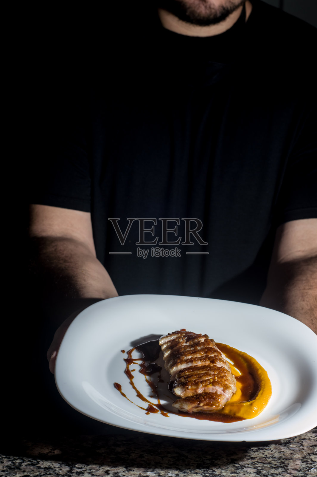 鸭肉酱和南瓜泥放在一个盘子里，一只手拿着，有复制空间照片摄影图片