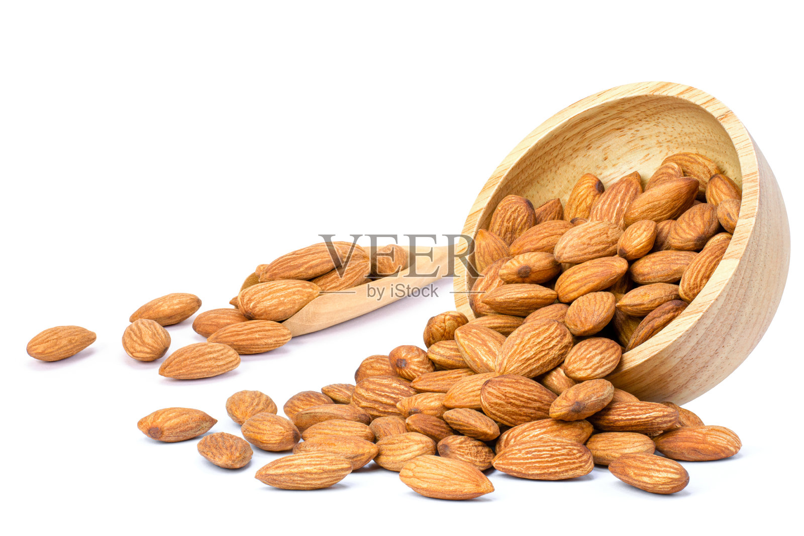 杏仁果放在木碗里倒在白色的上面照片摄影图片