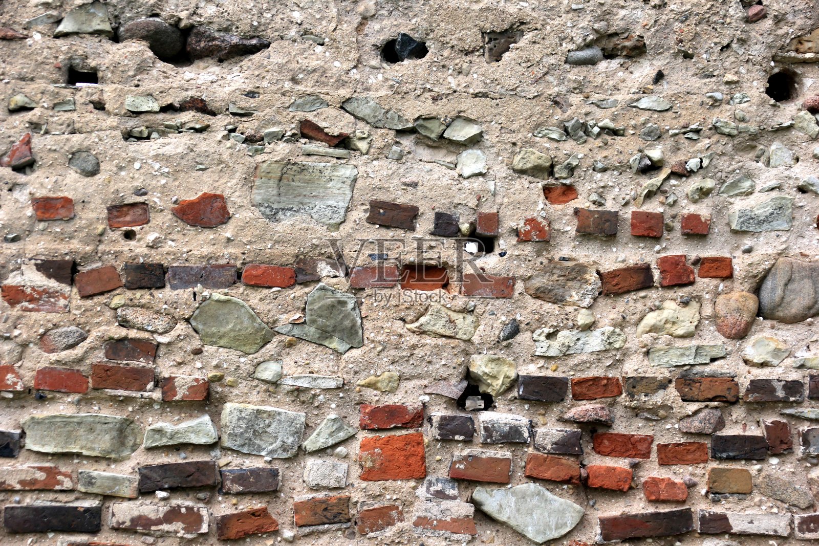用红砖和石头砌成的破旧砖石墙照片摄影图片