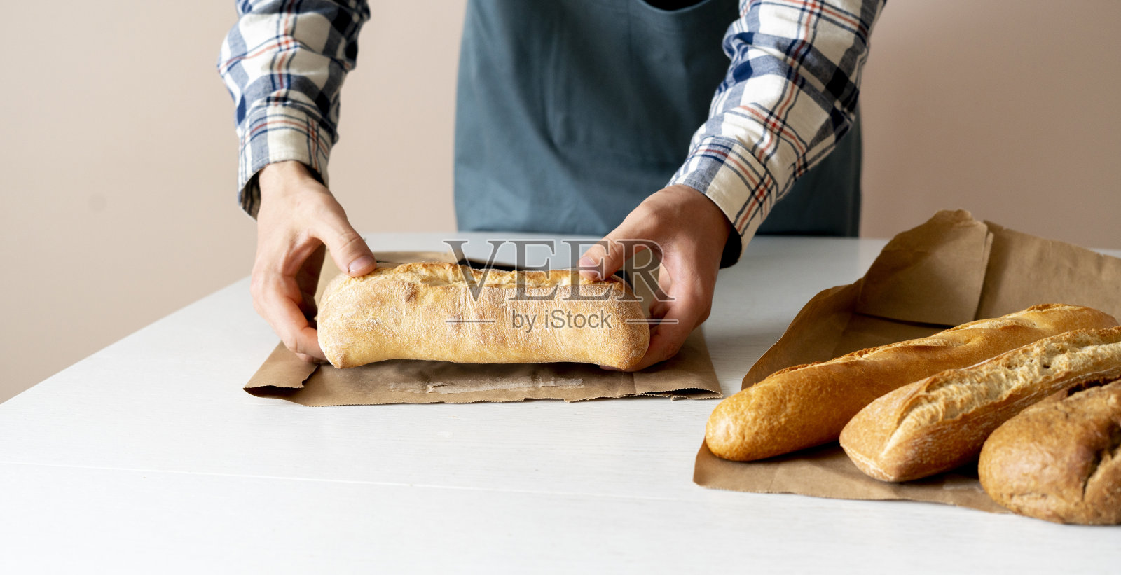 厨师把刚烤好的面包包在纸里照片摄影图片