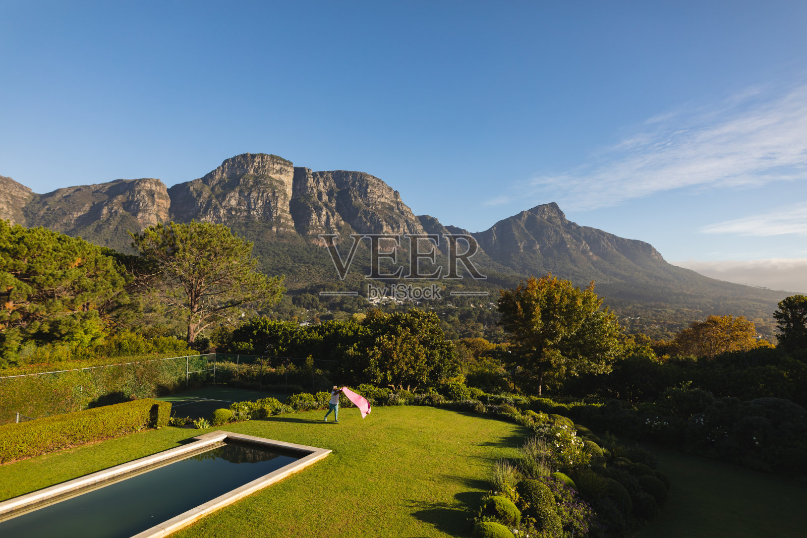 非洲裔美国妇女把瑜伽垫在草地上的室外游泳池在农村照片摄影图片