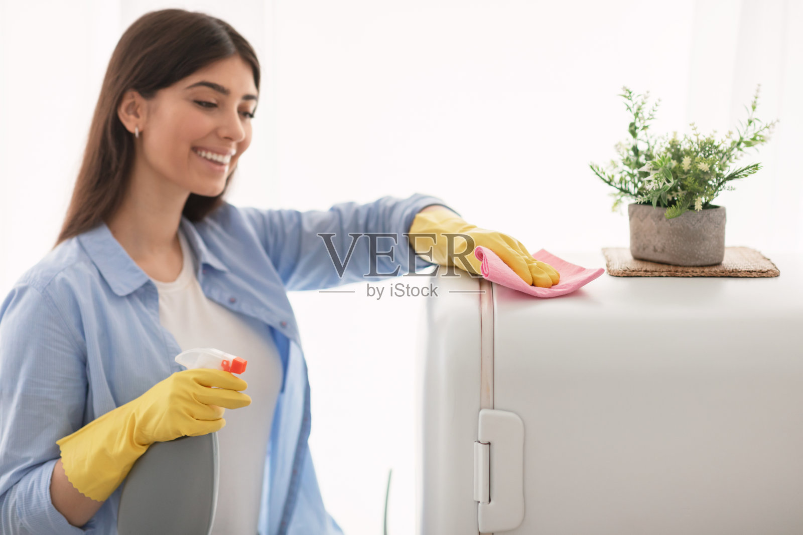 快乐的年轻家庭主妇在厨房清洁餐桌照片摄影图片