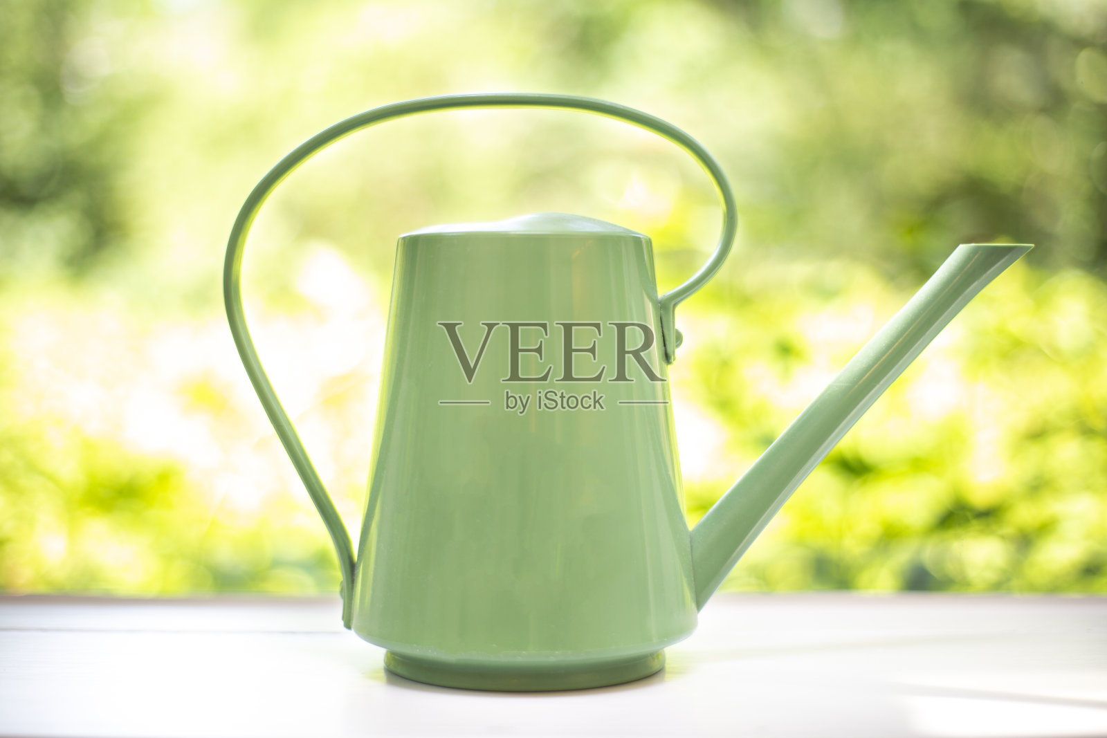 现代喷壶设计以绿色自然的叶子为背景，自然的色彩放在木架上。时尚的植物浇水装饰照片摄影图片