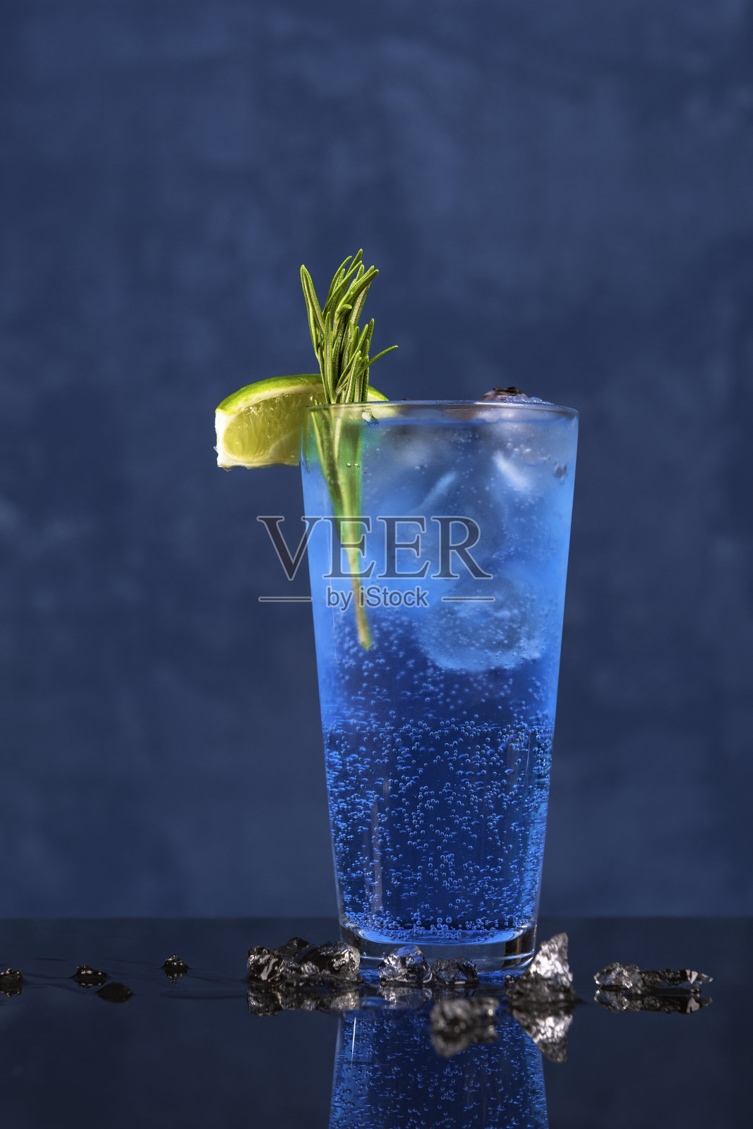新鲜的蓝色泻湖夏季鸡尾酒在海洋蓝色的背景。照片摄影图片