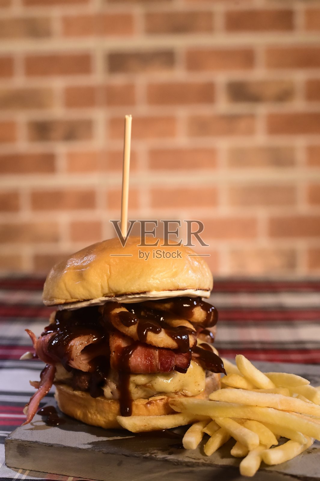 模糊的背景上的桌子上有汉堡包三明治和开放的奶油蛋卷面包、芝士薯条和培根酱照片摄影图片