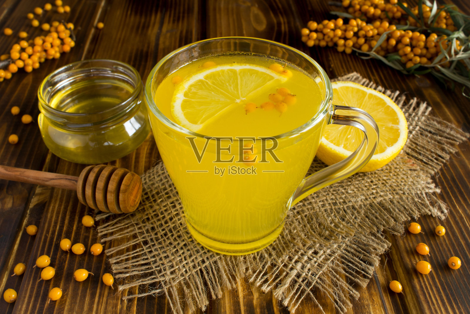 沙棘、柠檬和蜂蜜的热茶，在质朴的木质背景下照片摄影图片