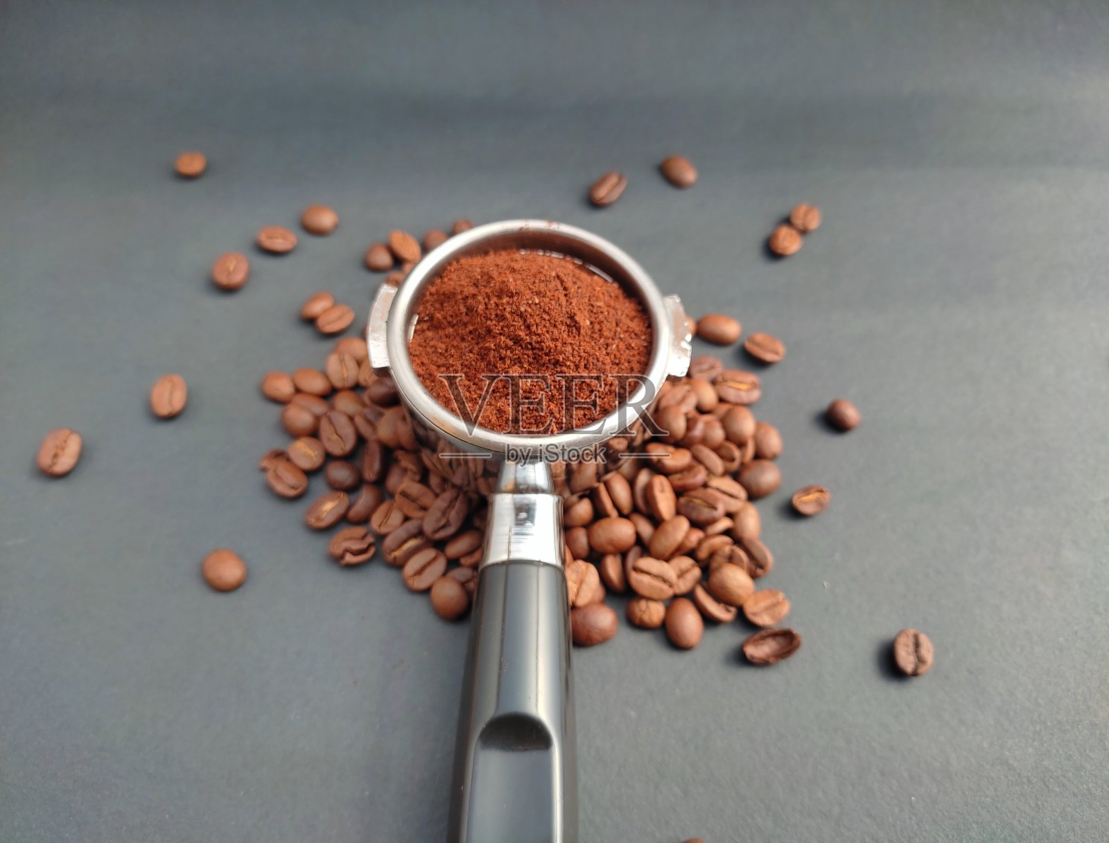 磨碎的咖啡在porta滤镜支架上的黑色背景照片摄影图片