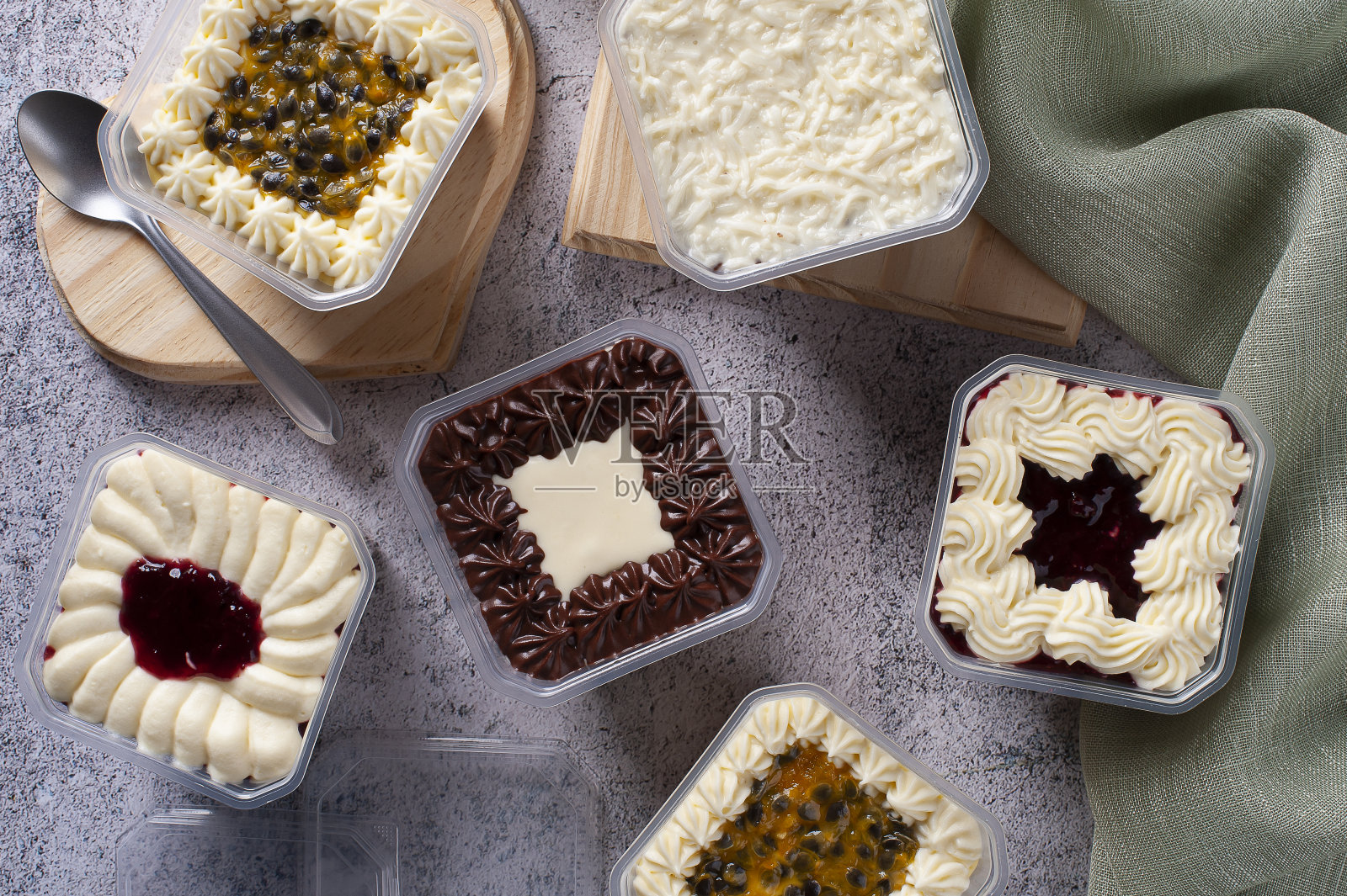 各种蛋糕在锅中交付。草莓，百香果，巧克力和椰子口味。前视图。照片摄影图片