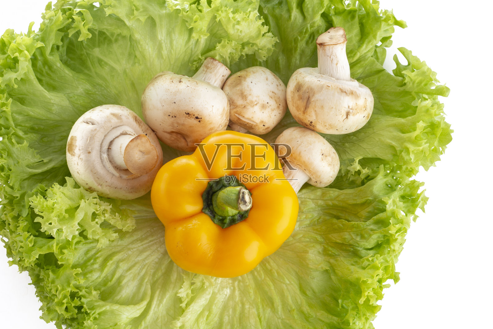 蘑菇和甜椒，在一些白色的生菜叶子上照片摄影图片