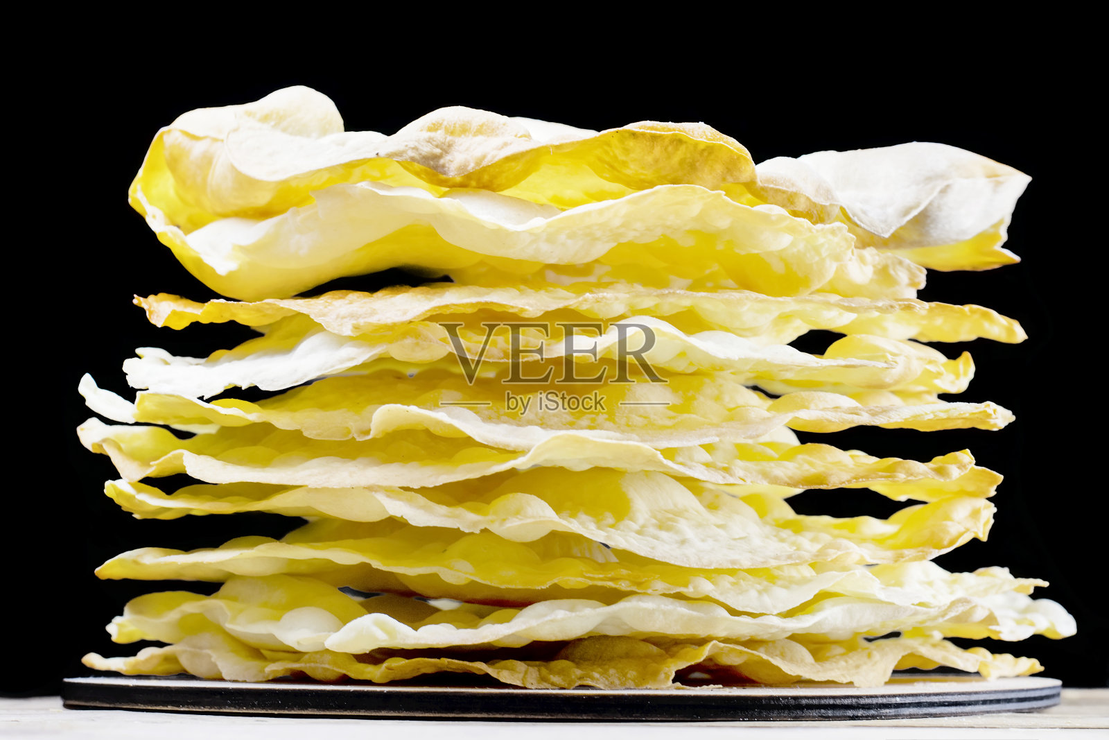 一个巨大的蛋糕堆是拿破仑在一个黑色孤立的背景。特写镜头照片摄影图片