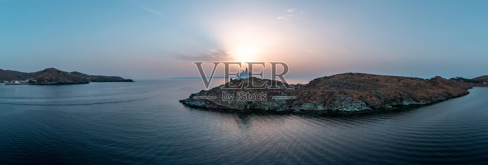 希腊Kea Tzia岛。灯塔在岩角，天空，大海背景。照片摄影图片