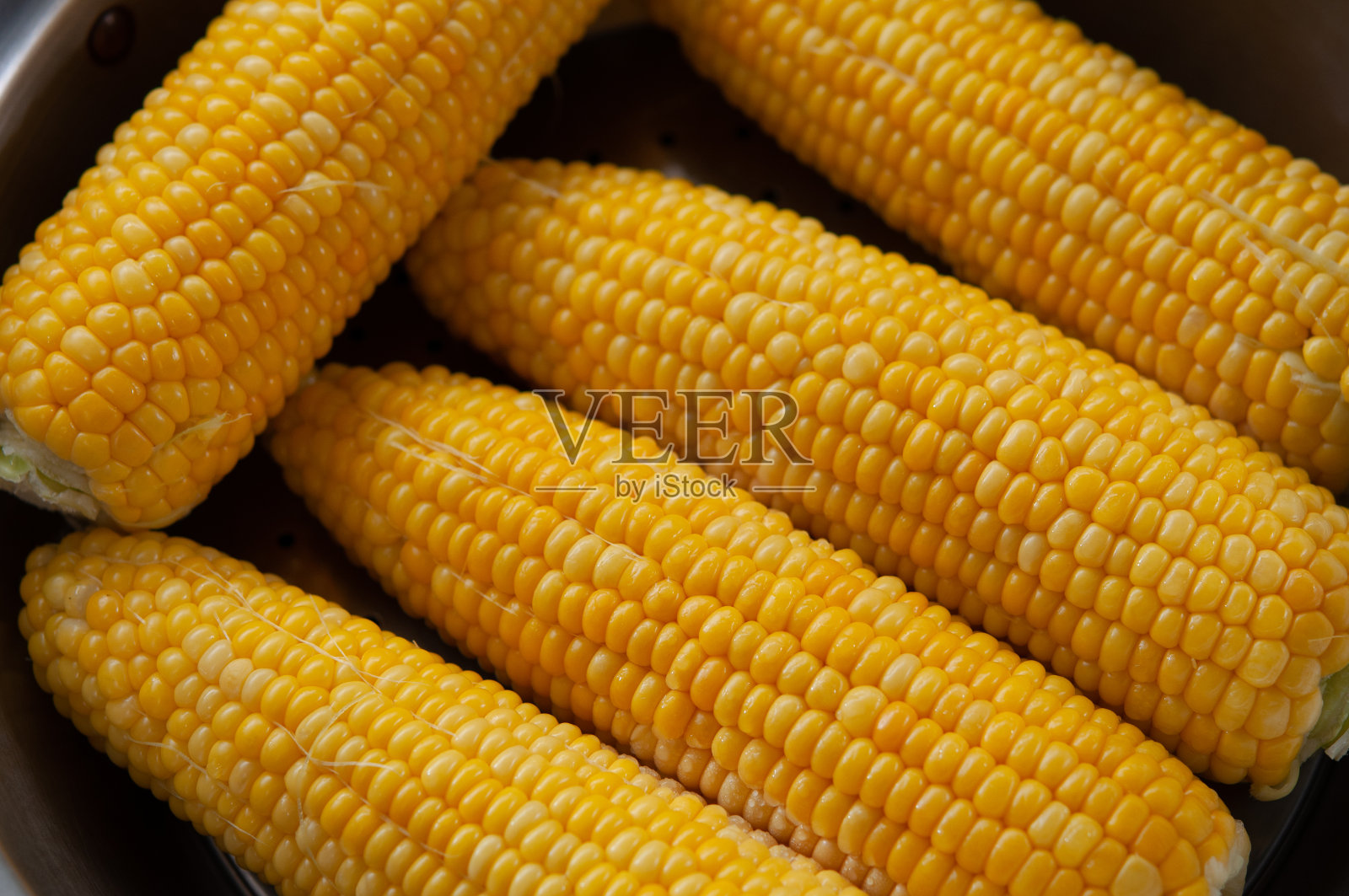 在平底锅里蒸熟的甜玉米。日本厨房的场景。照片摄影图片