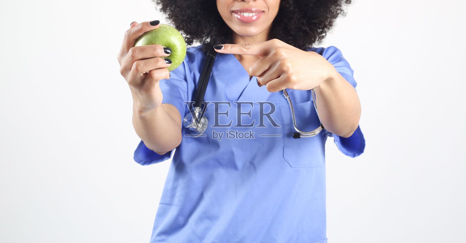 女医生手里拿着一个苹果，非洲女性白人背景照片摄影图片
