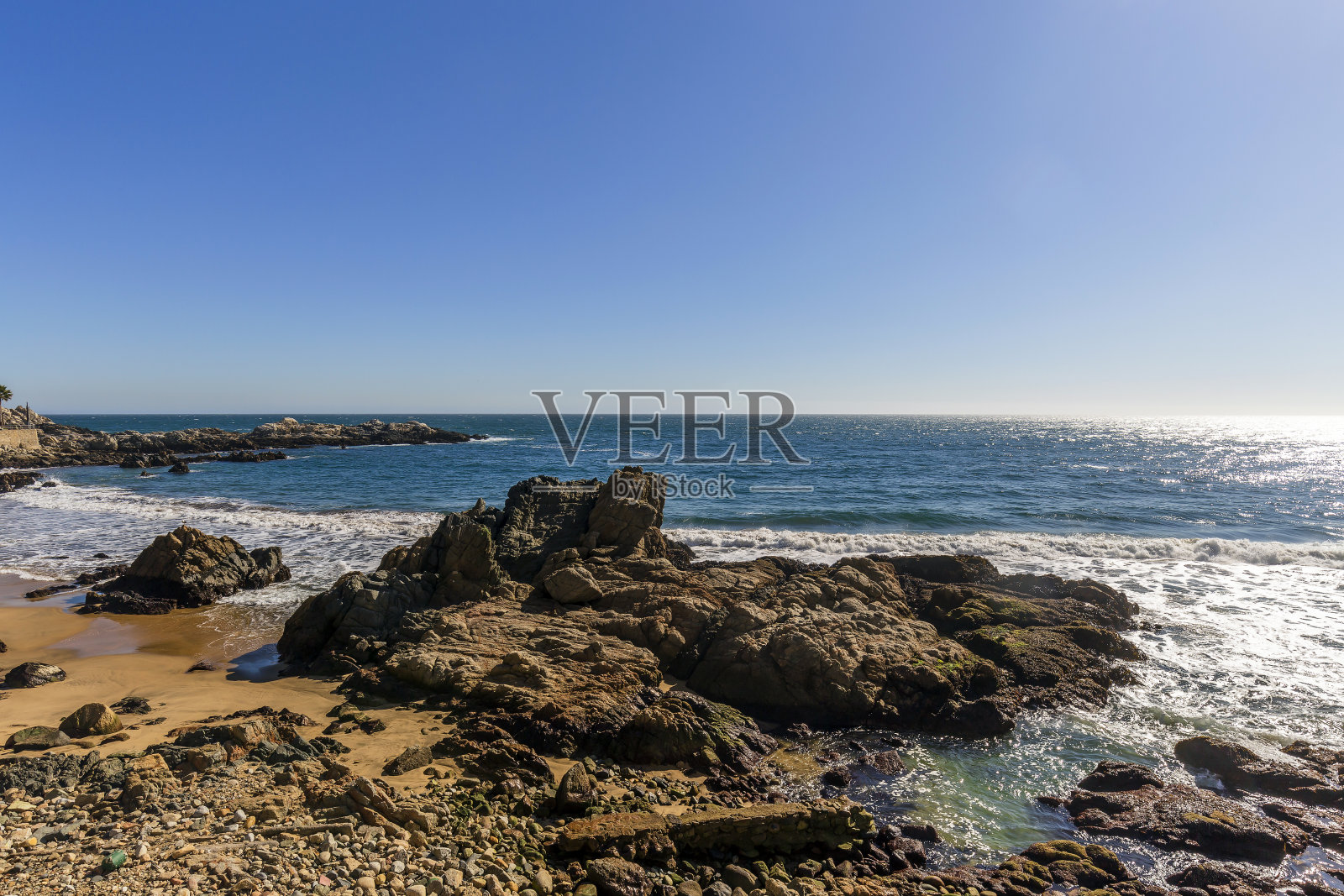 在一个阳光明媚的日子海浪撞击岩石的观点照片摄影图片