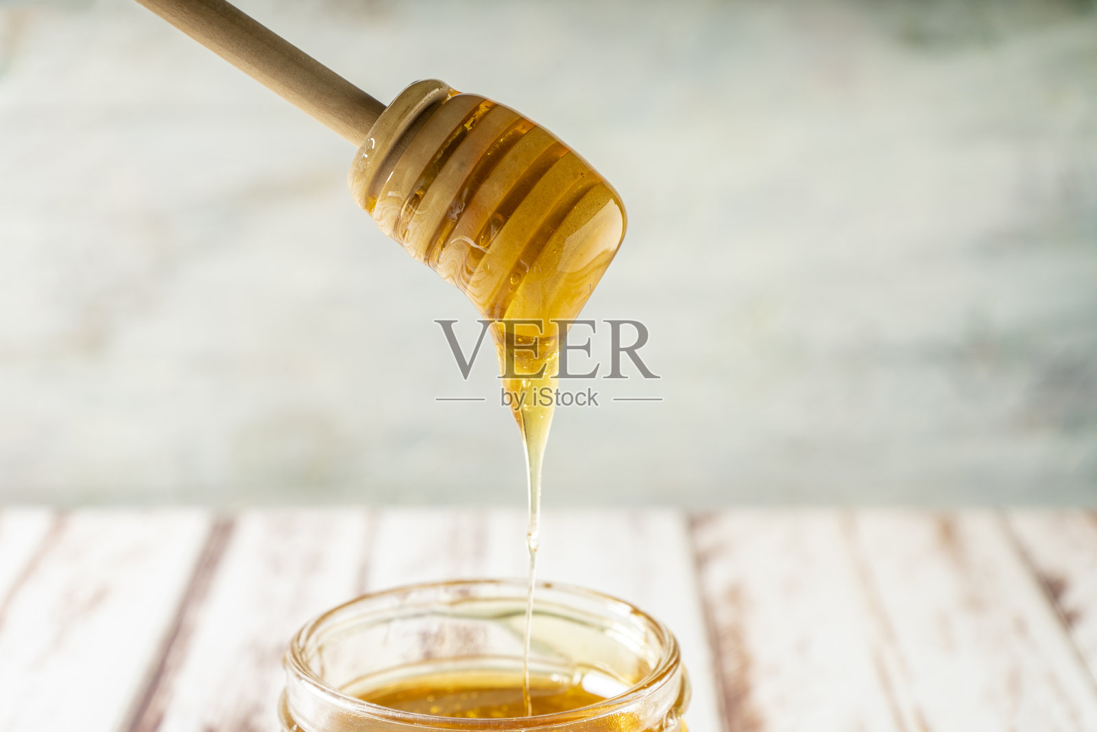 从蜜蜂身上滴下纯有机蜂蜜的蜂蜜棒。照片摄影图片