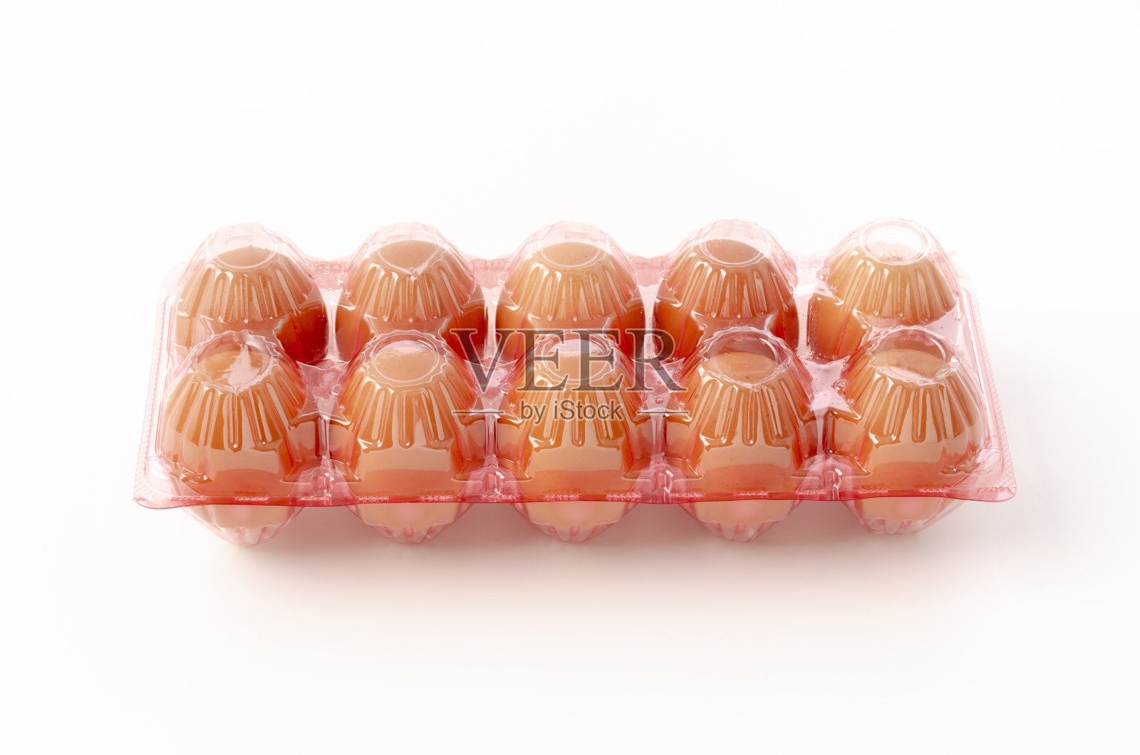 白色背景的塑料容器中的棕色鸡蛋照片摄影图片