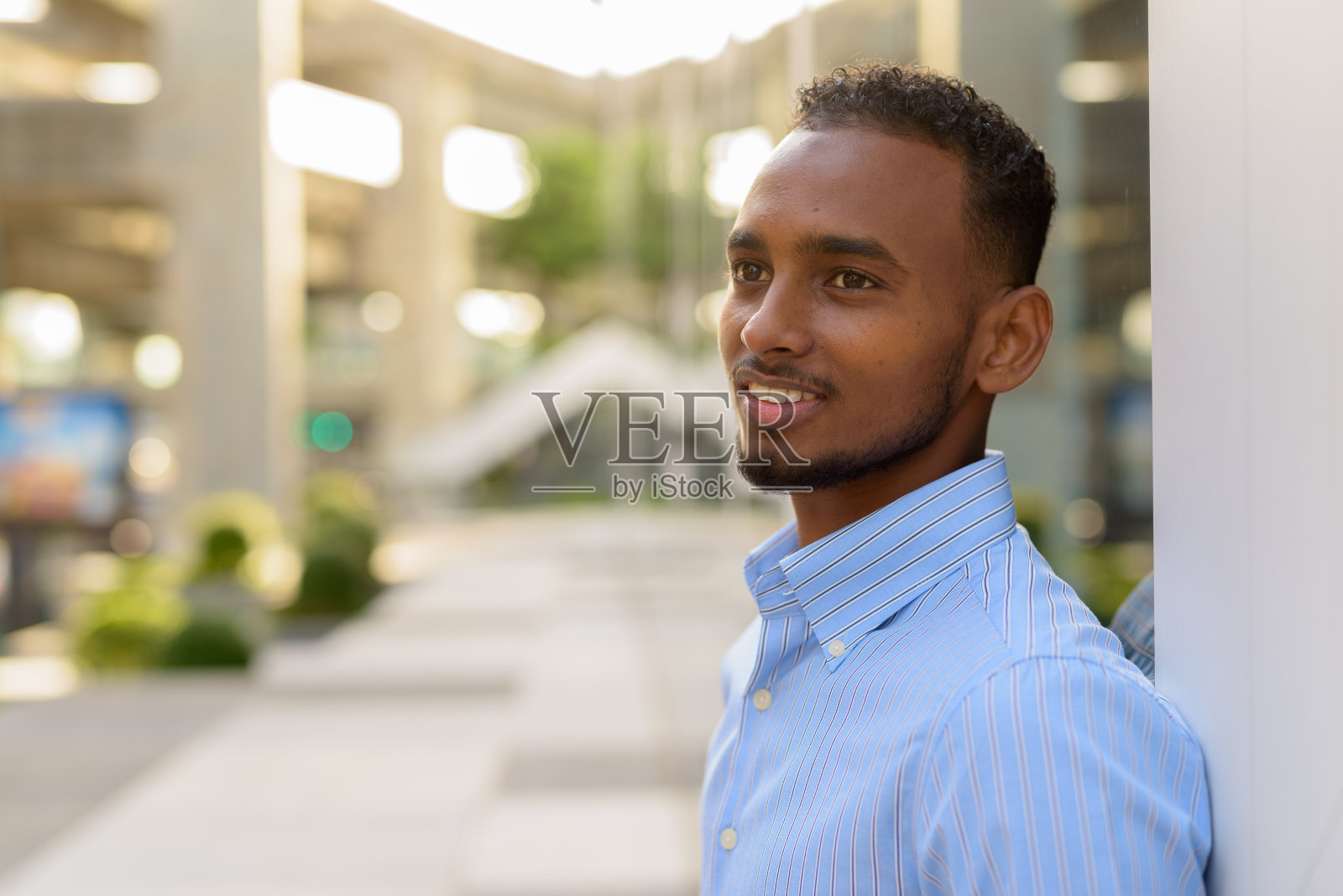 帅气的非洲黑人商人在夏天的城市户外微笑的肖像照片摄影图片