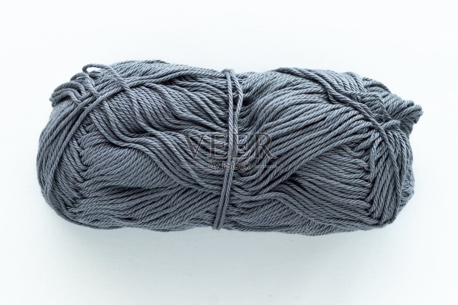 以手工编织为主题，以白色编织为背景，画面中心为长方形的深灰色球照片摄影图片