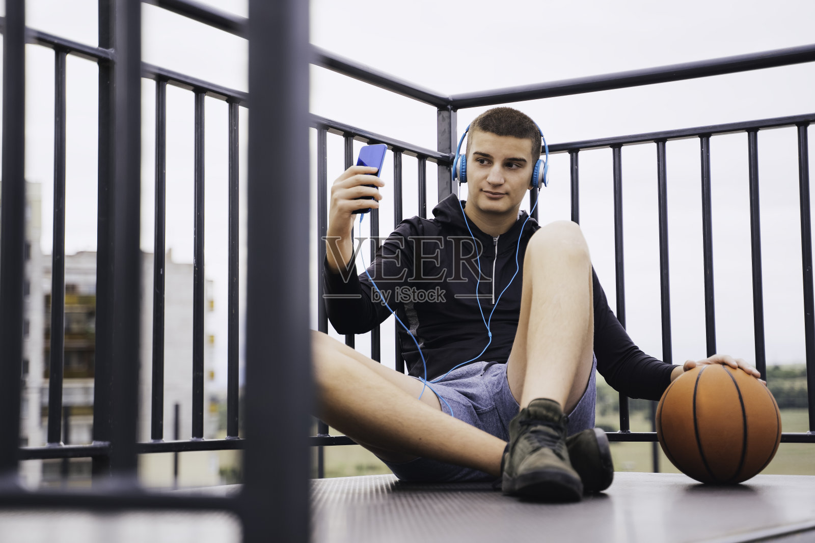 听音乐的少年。使用智能手机、手机。副本的空间。照片摄影图片